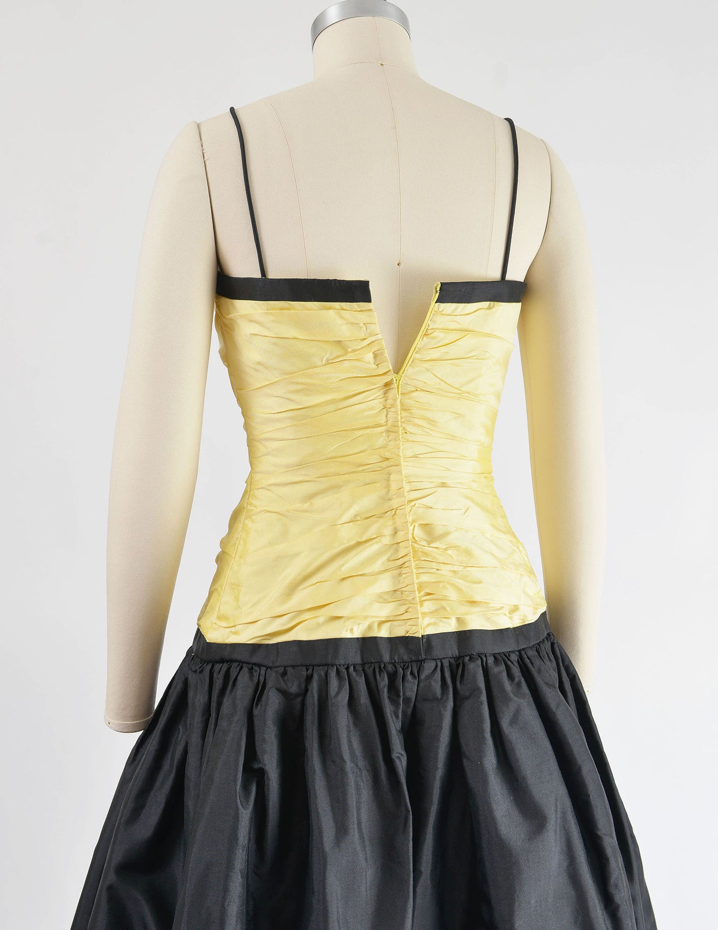 Close up back view of yellow and black dress.