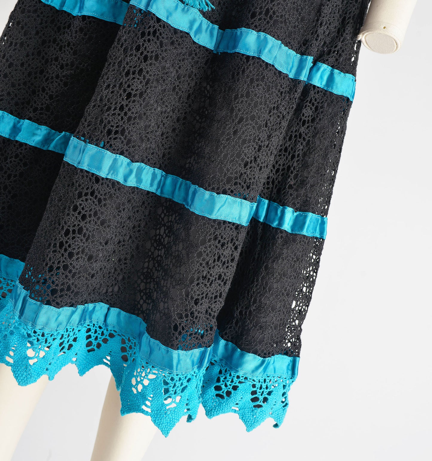 Close up view of black and blue lace dress.