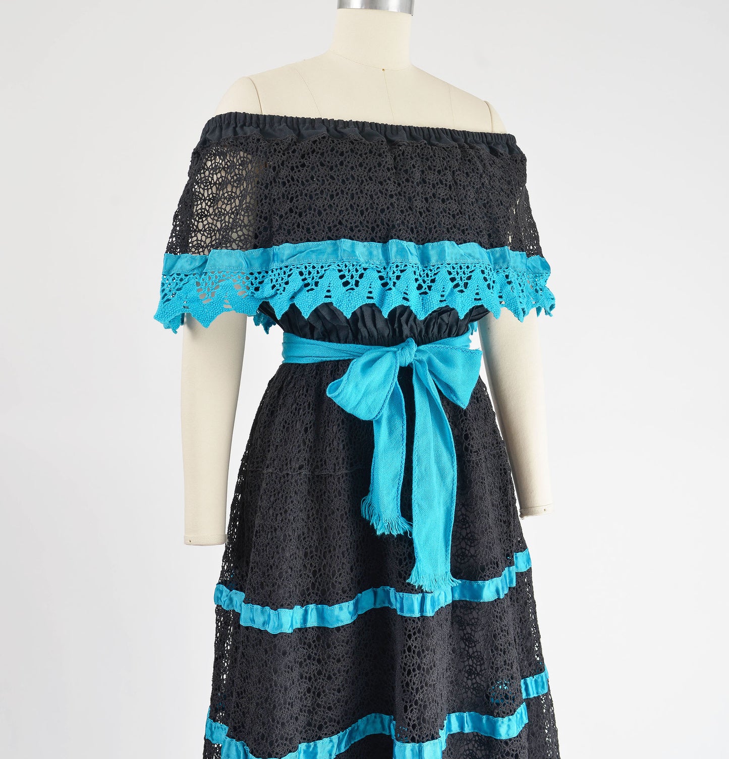 Side view of 80s black and blue off shoulder lace dress.