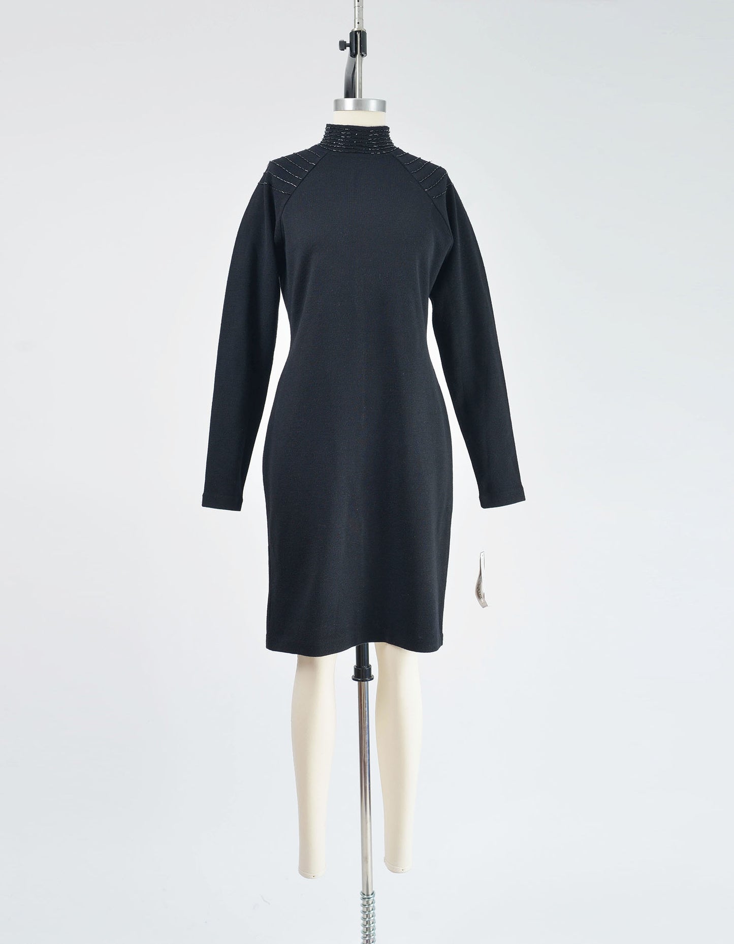 Full front view of black sweater dress with beading along the shoulders.