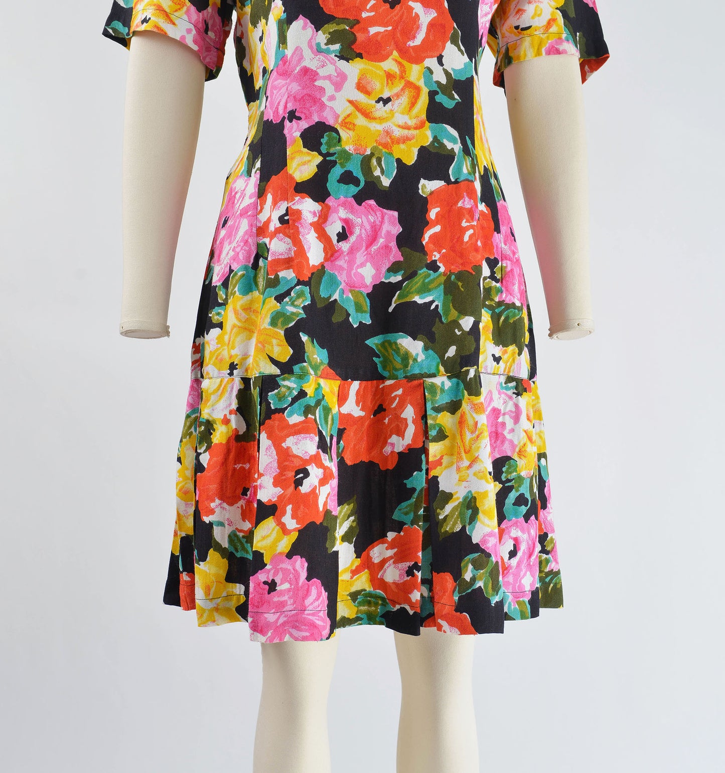 View of pleated hemline on 90s floral dress.