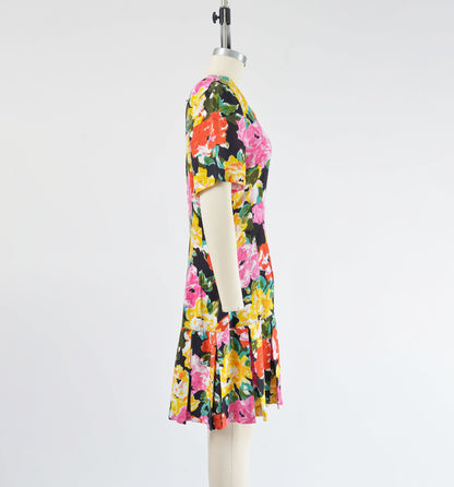 Side view of vintage 90s colorful floral print dress. Sheath silhouette with pleated hem.