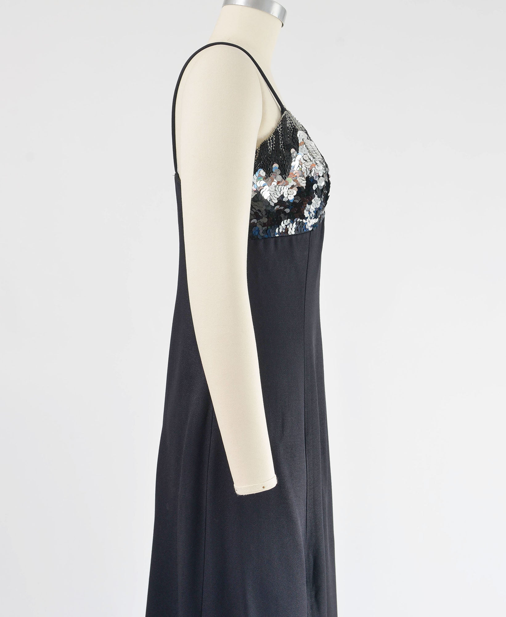 Side view of Vintage black formal maxi dress with spaghetti straps. Metallic silver sequin and beaded bodice.