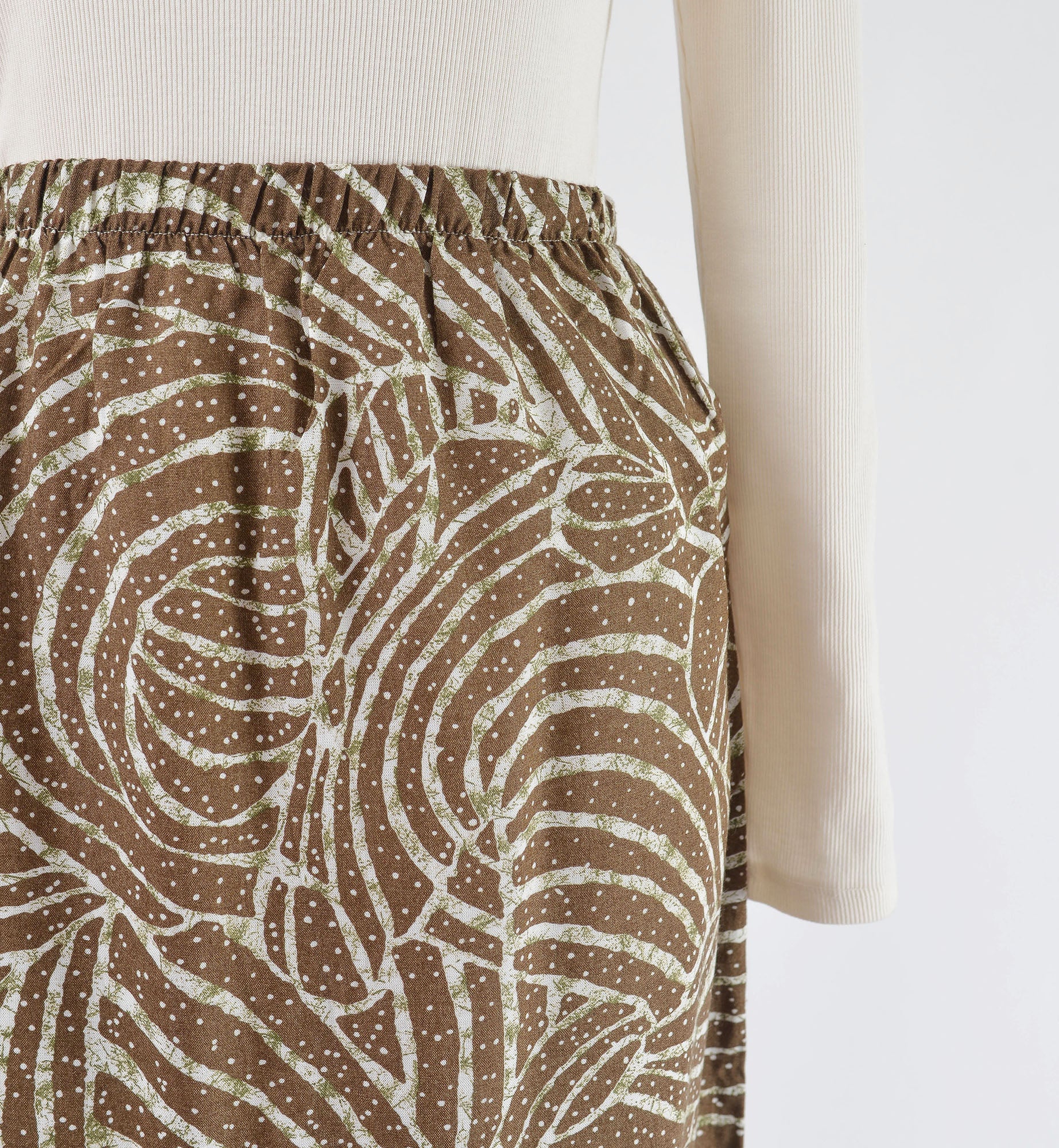 Close up view of elastic waist on midi skirt.