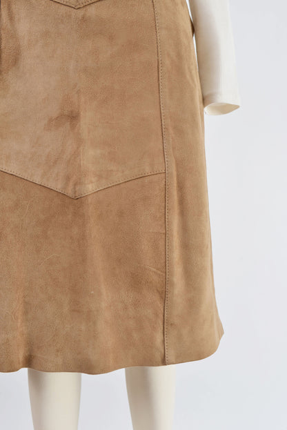 Close up view of hemline on 70s light brown suede skirt.