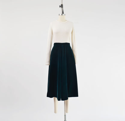 Full front view of 1980s dark green velvet midi skirt.