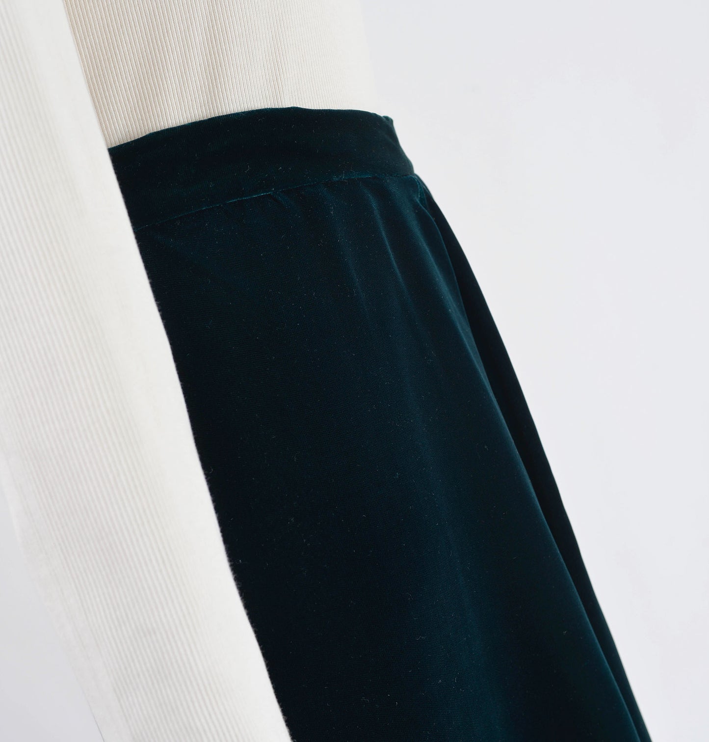 Close up view of dark green velvet skirt waistline.