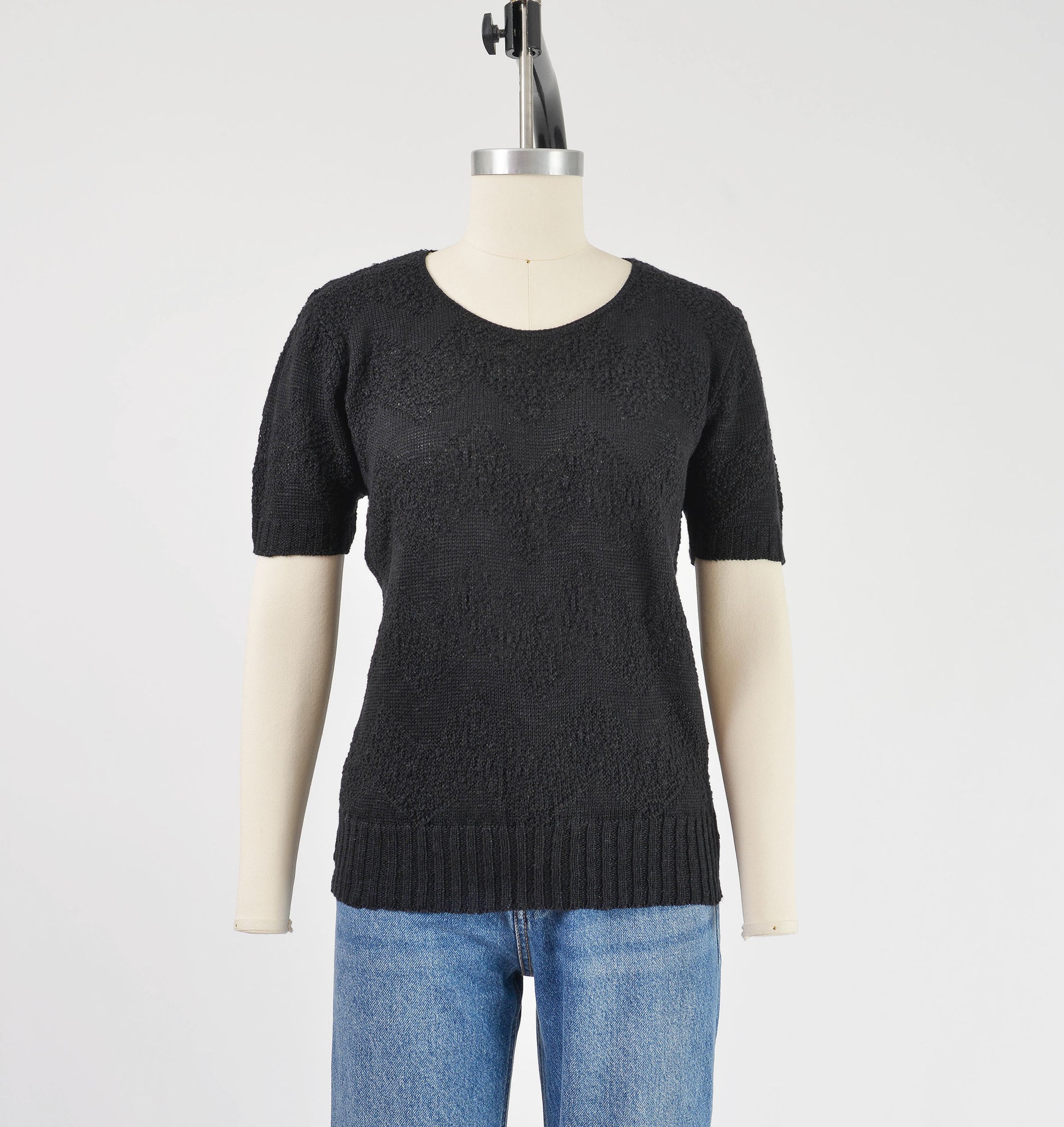 Front view of vintage 80s black short sleeve sweater with zig zag stripes.