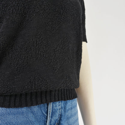 Close up view of knit on black short sleeve sweater.