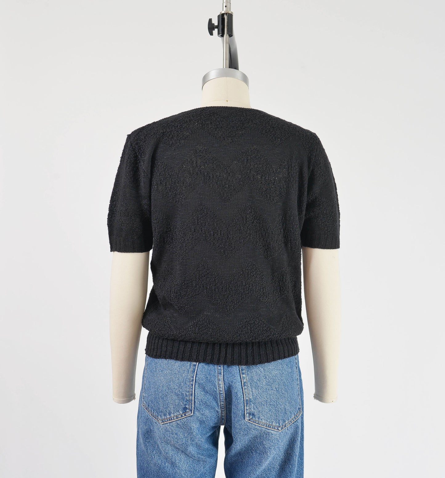 Back view of vintage 80s black short sleeve sweater with zig zag stripes.