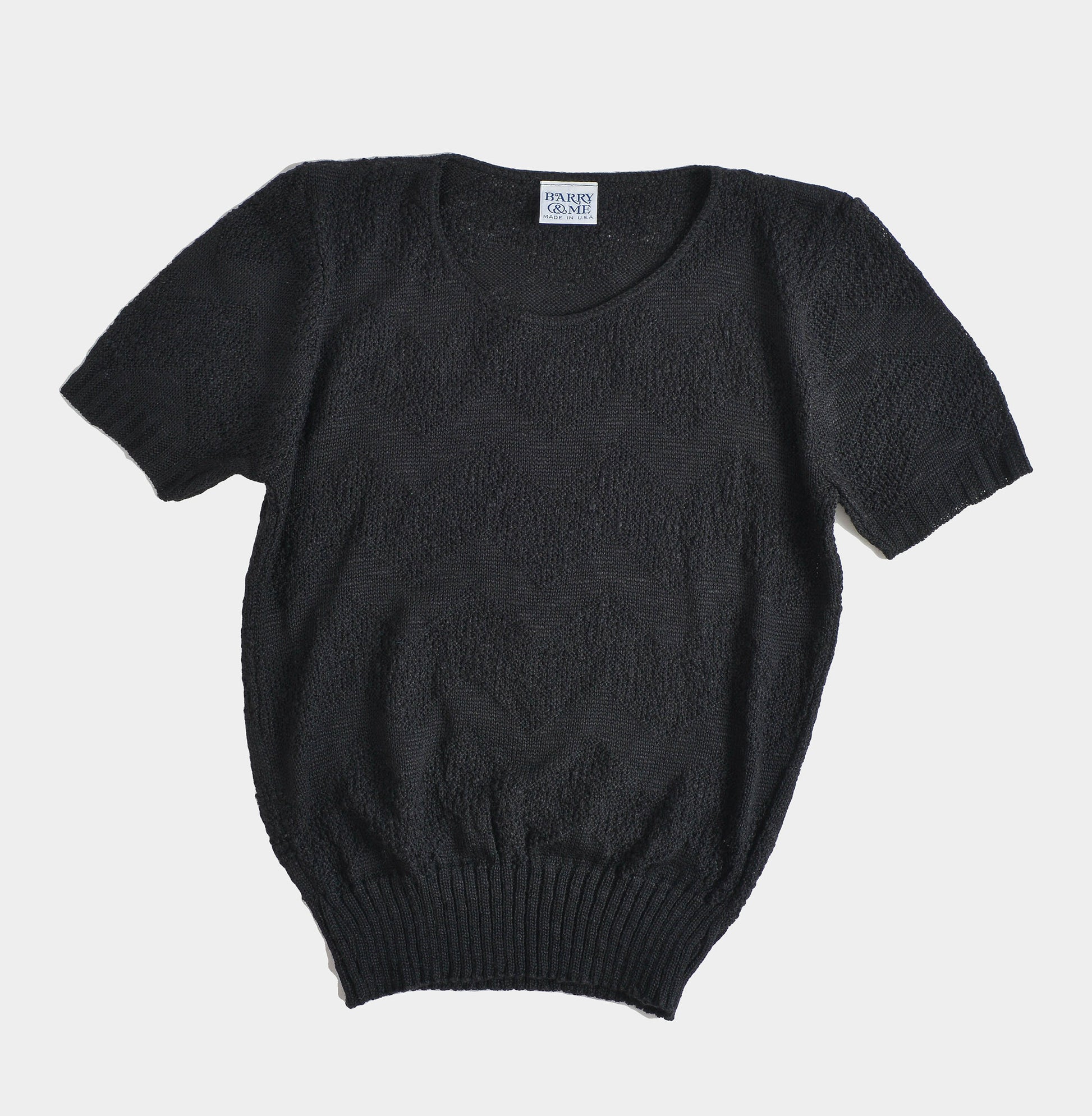 Flat view of 80s black short sleeve sweater. 