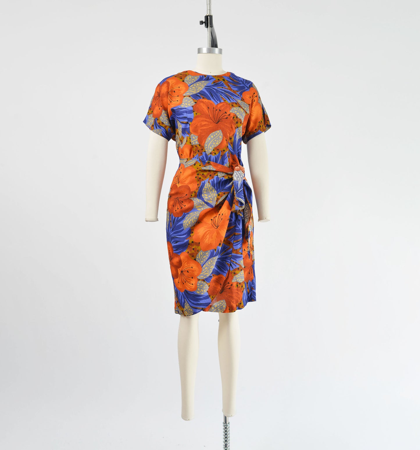 Full front view of vintage 90s floral print sarong style dress that ties at side waist.