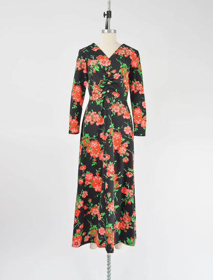 Full view of vintage 70s black floral print maxi dress with a-line silhouette.