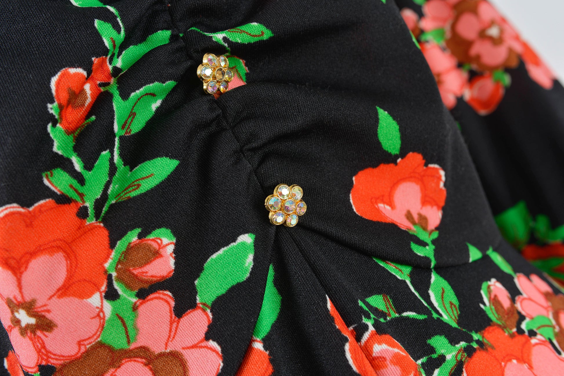 Close up view of rhinestone buttons on 70s floral maxi dress.