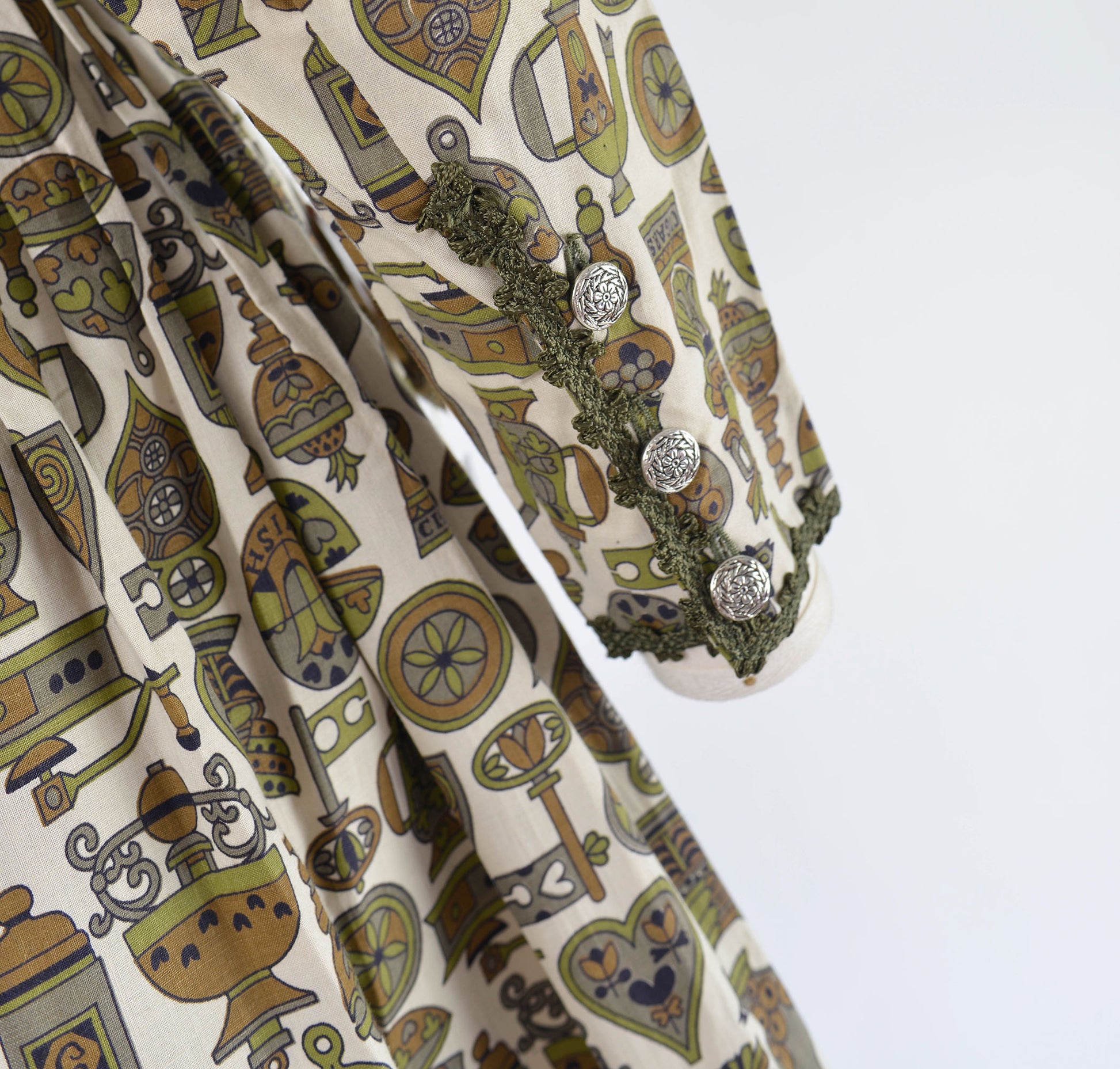 Close view of sleeve with buttons on 60s vintage novelty print dress.