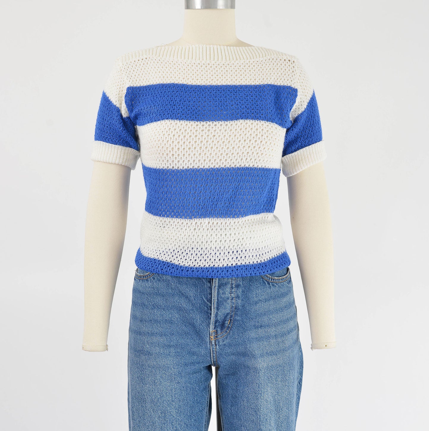 Front view of  80s blue and white striped sweater. Semi sheer open knit top tucked into jeans.