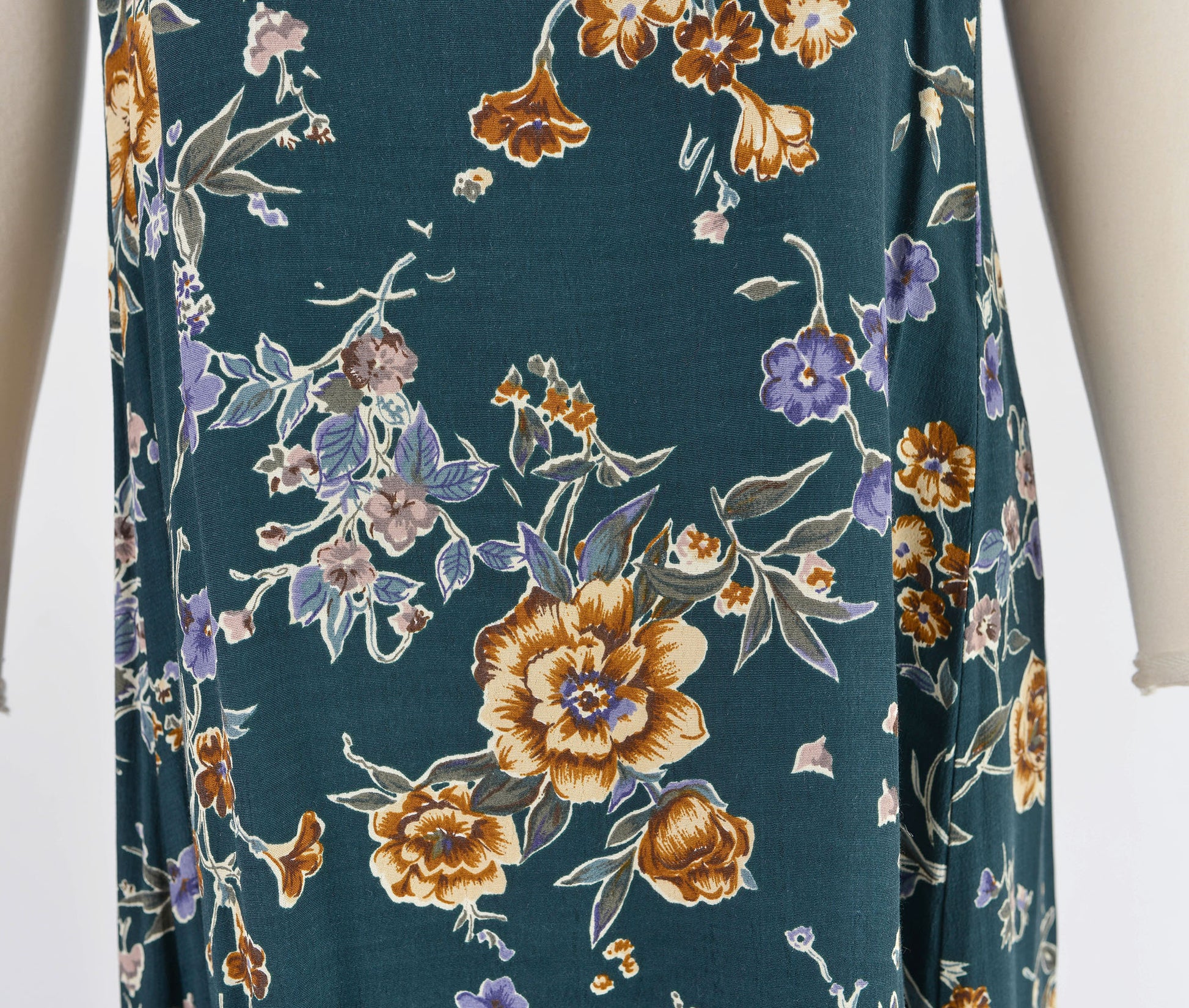 Close up view of dark green floral dress. Shows the fabric up close.