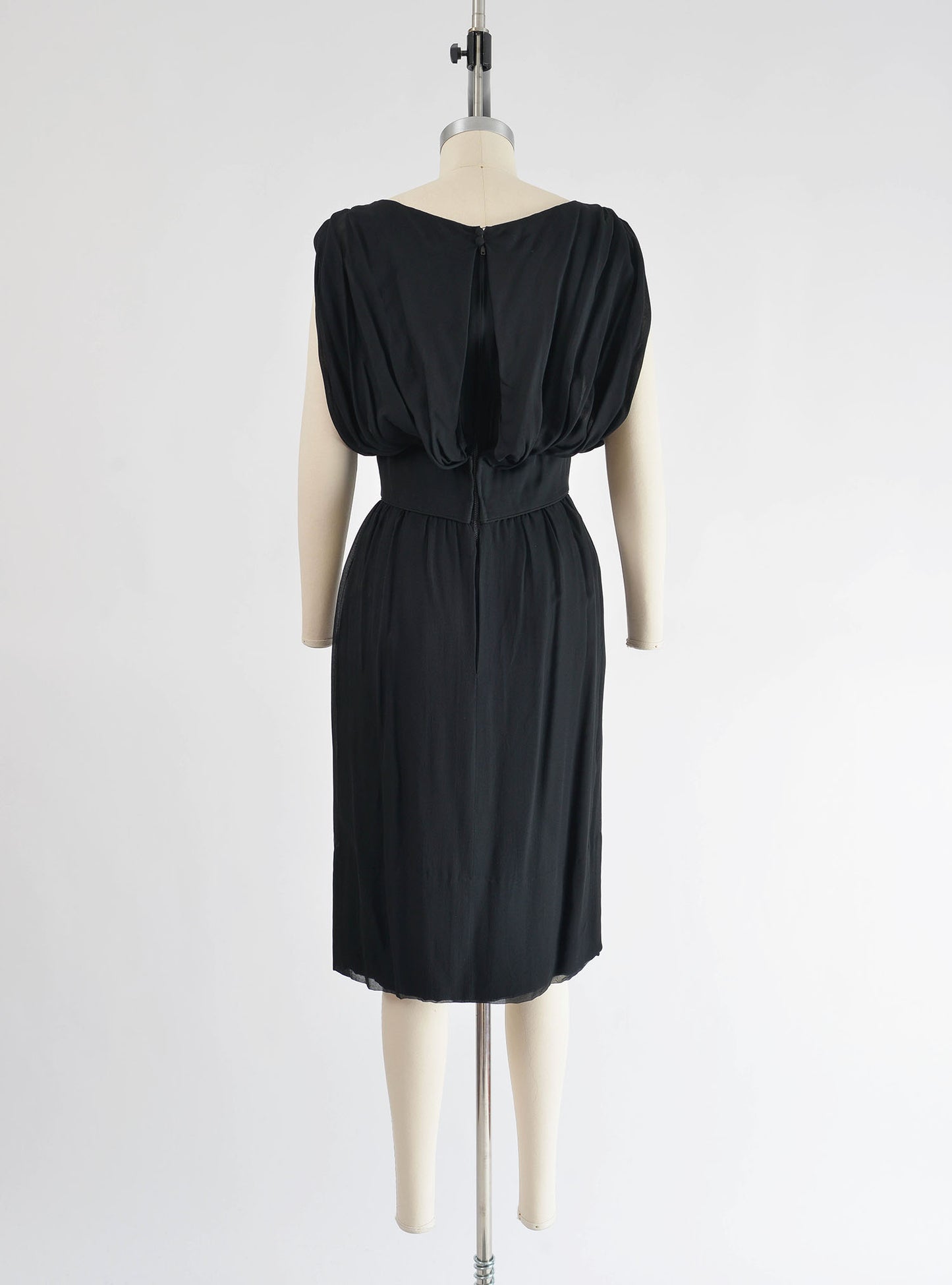 Full length back view of 1960's black chiffon cocktail dress. 