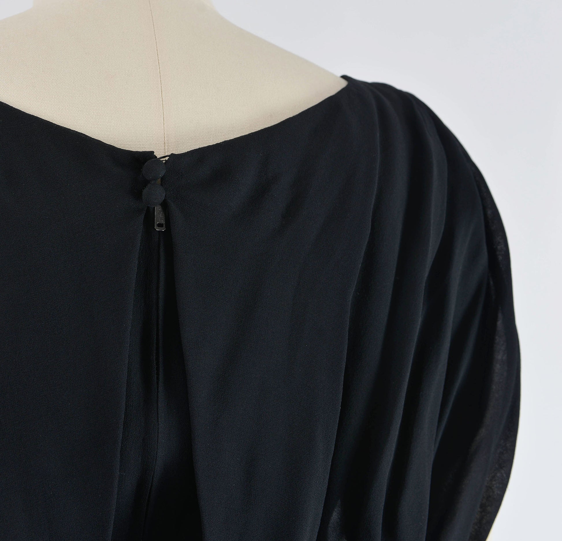 Neck button closures of black 1960's cocktail dress. 