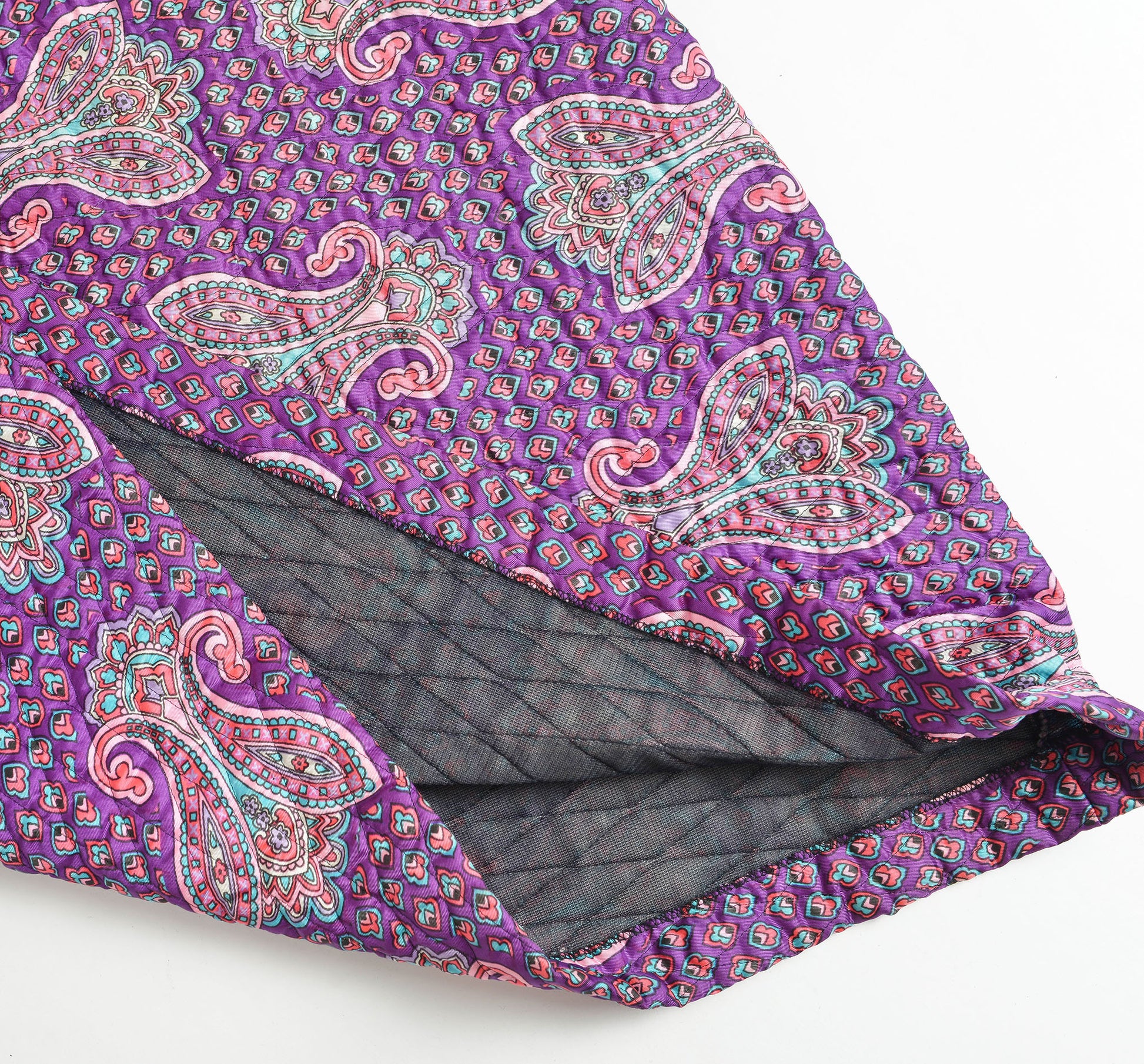 Flat view of vintage 70s purple quilted paisley fabric. 