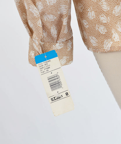 Close up view of hang tag on blouse sleeve.