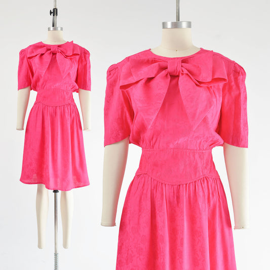 Vintage 80s pink Barbiecore style dress with bog bow at the neck.